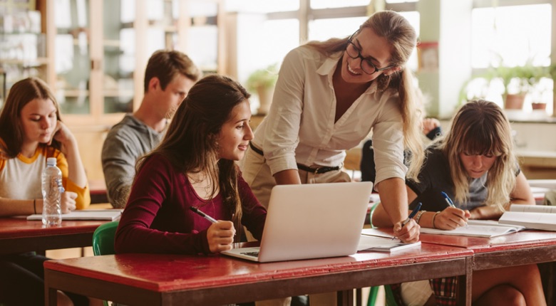 Smiling,Female,Lecturer,Helping,Student,During,Her,Class.,Student,In